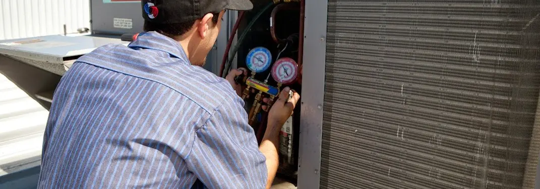 HVAC technician servicing a condenser unit in Independence
